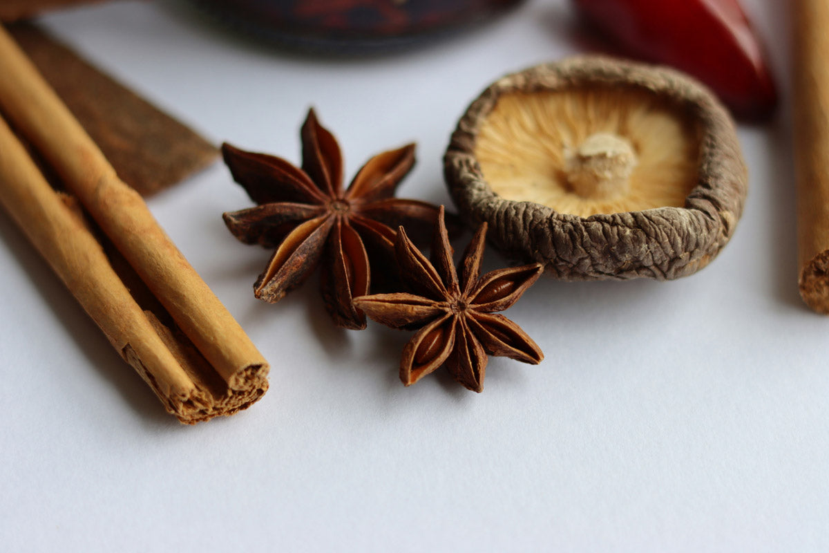 Sternanis, Zimt und Shitake Pilze auf einem hellen Untergrund