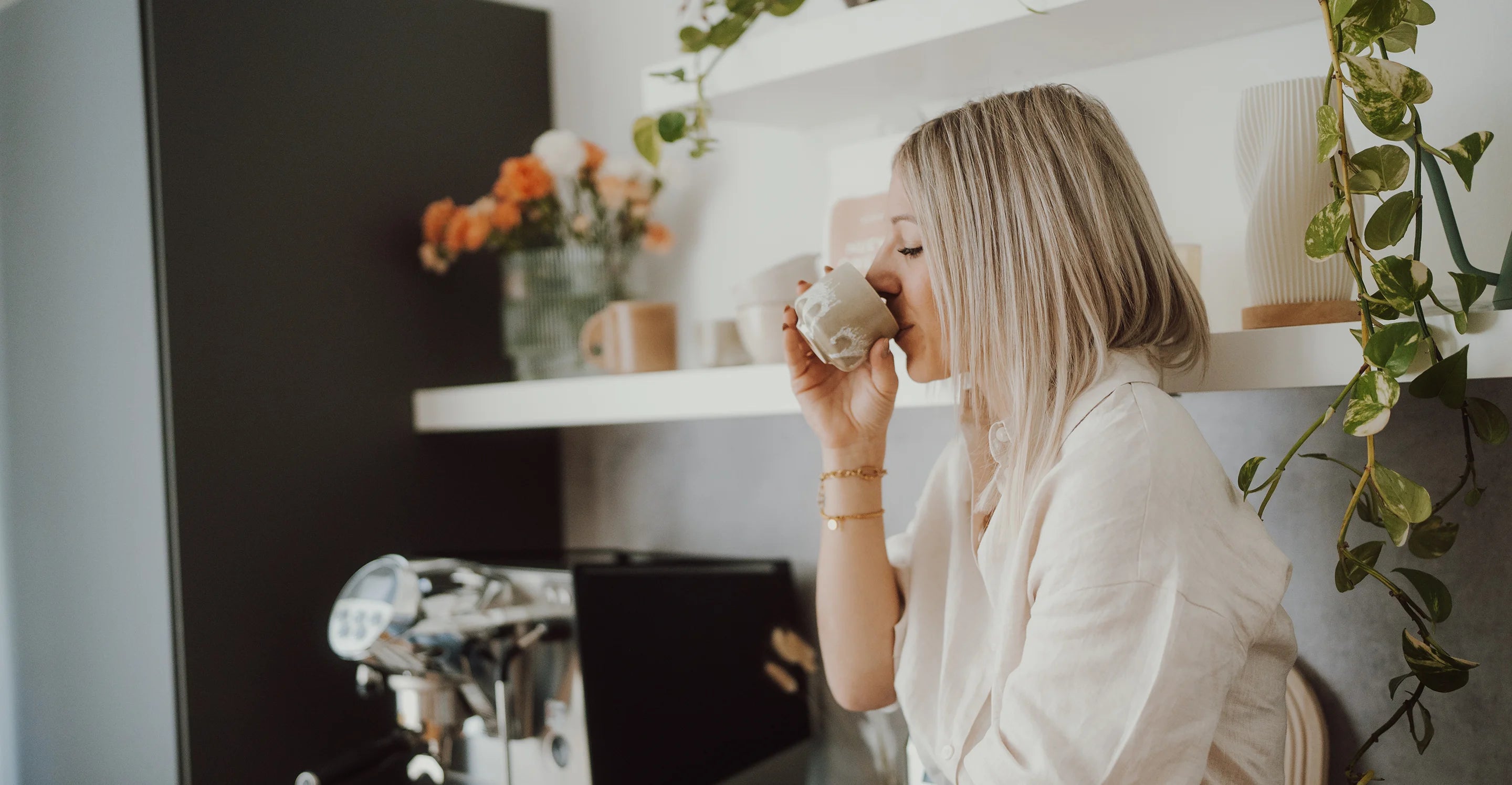 Eine Frau trinkt einen Espresso in einer modernen Küche