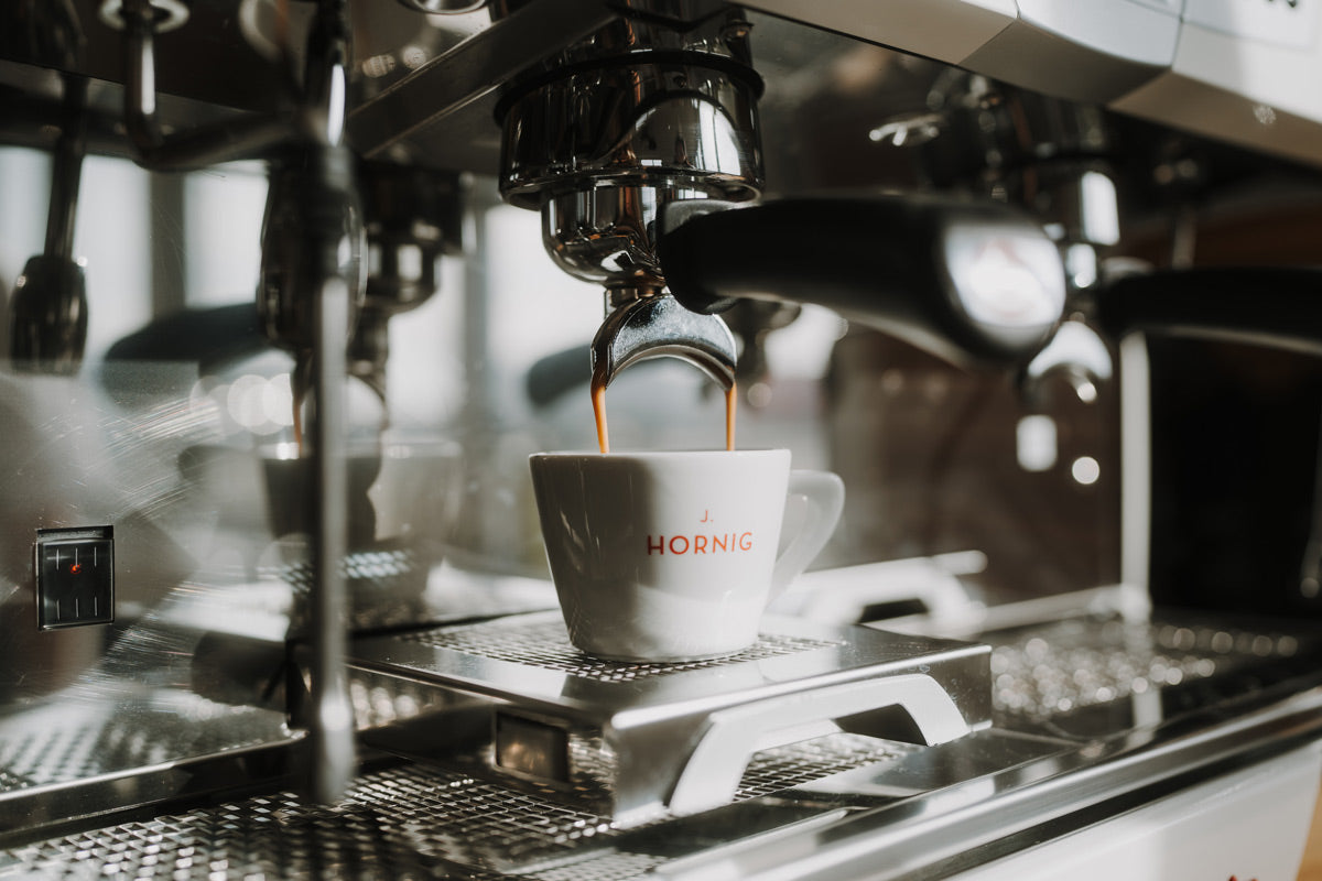 Kaffee fließt von einem Siebträger in eine Tasse von J. Hornig